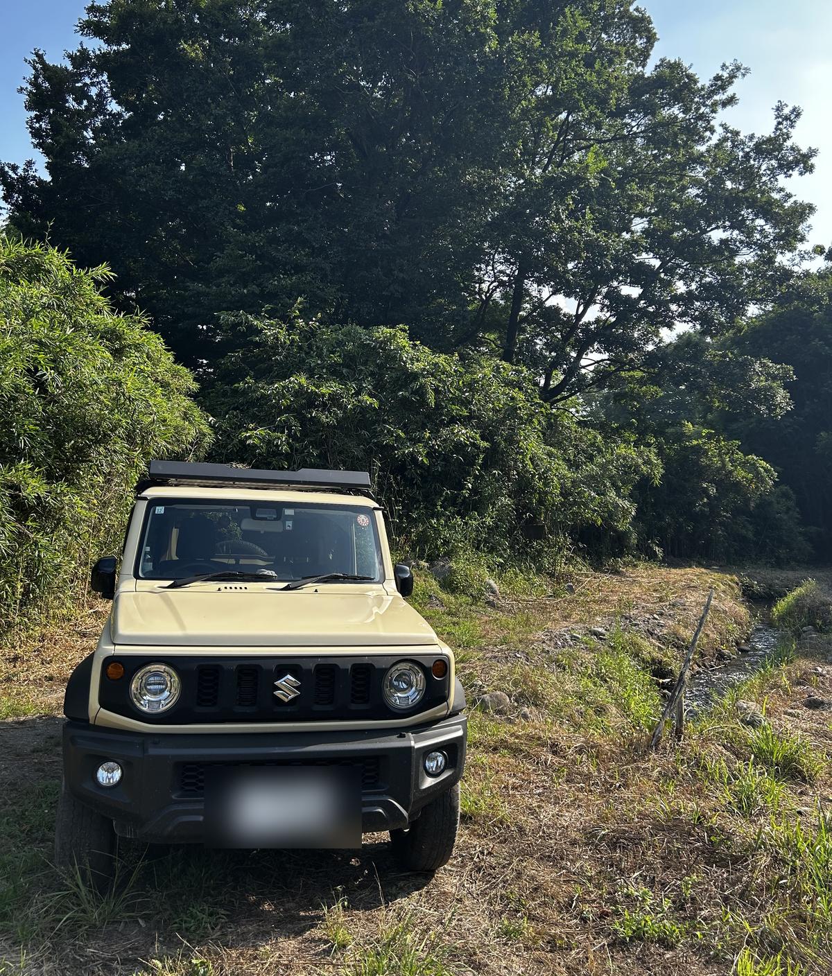 草地に停まるジムニーシエラ（JB74）の正面