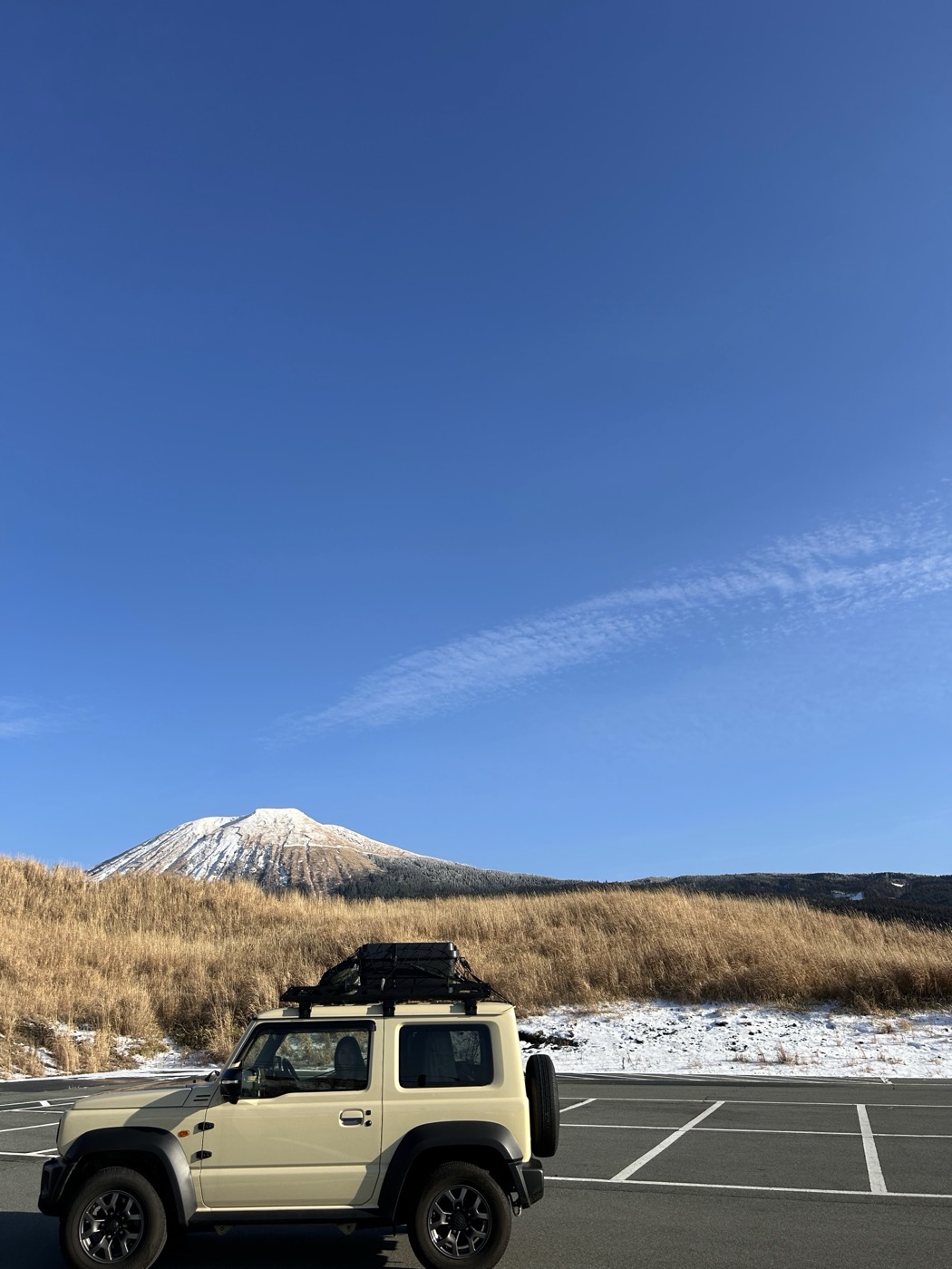 雪山を背景に停まるジムニーシエラ(JB74)